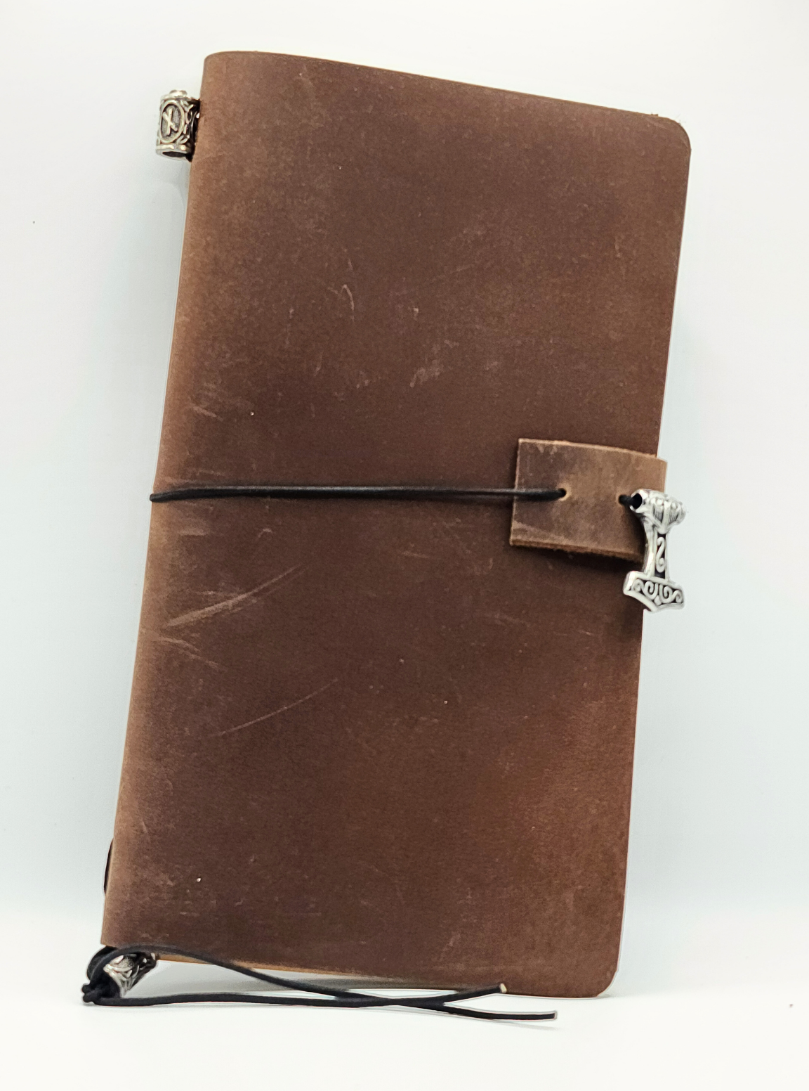 Odyssey Notebook – custom leather travel journal in brown and black with Nordic rune designs and Thor’s Hammer motif